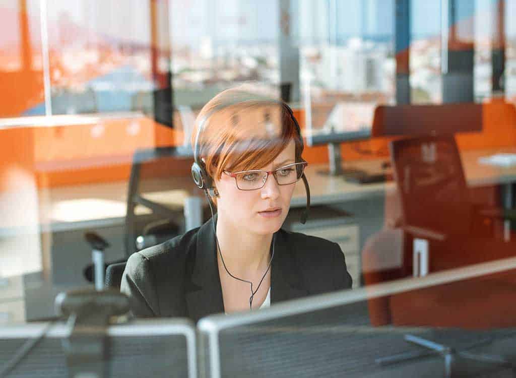 Woman wearing a headset while looking at her monitor